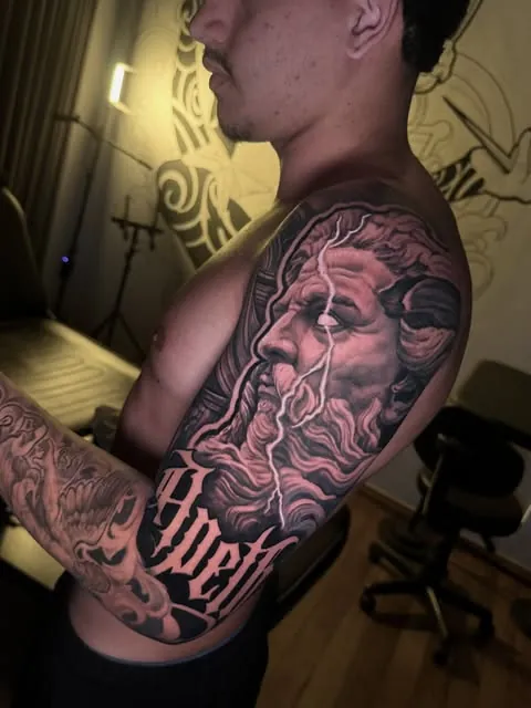 Deus grego barbado no ombro, com lettering